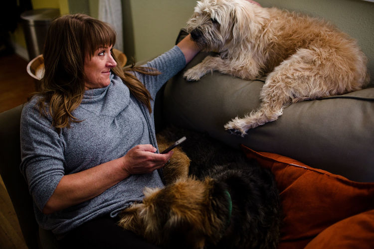 Mid 40's woman sitting on chair with her two large dogs