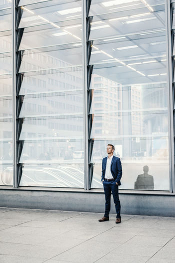 Full length of man standing against modern building