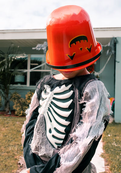 Cute boy in halloween costume. boy in skeleton costume with pumpkin bucket trick or treating outside