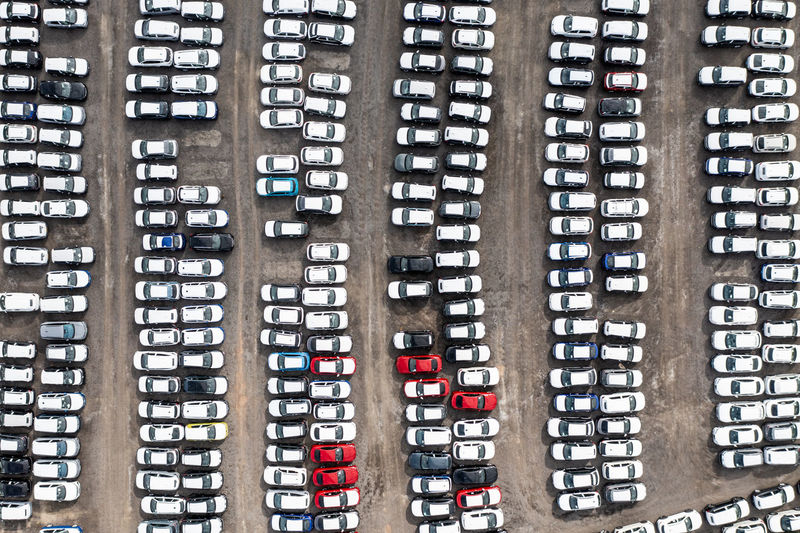 Aerial view of rows of newly built cars ready for export import and delivery to sales dealerships