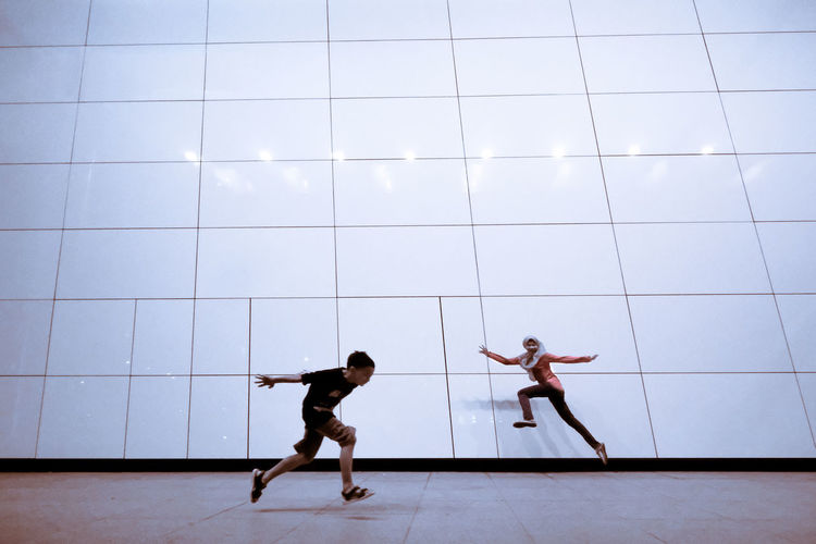 Siblings running on footpath