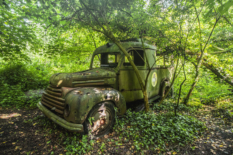 Old abandoned car on field