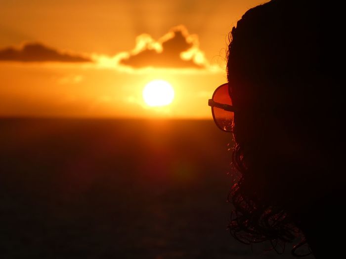 Portrait of silhouette man against orange sunset sky