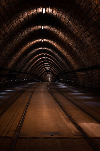 Illuminated railroad tracks in tunnel