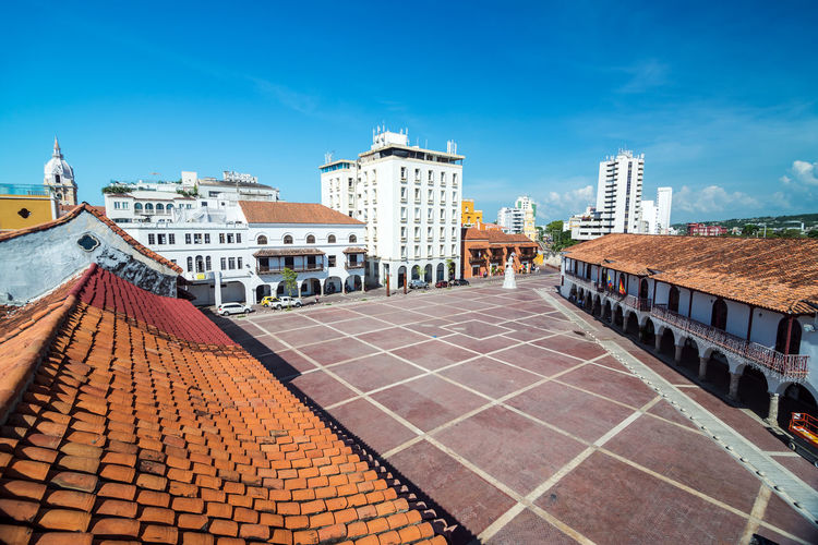 Buildings by plaza de la aduana against blue sky