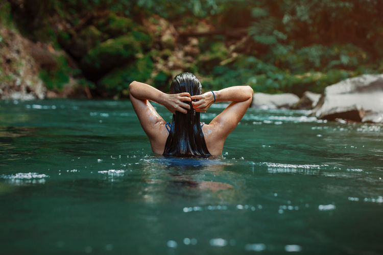 Low section of woman swimming in lake