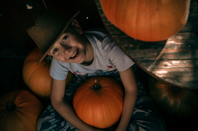 Portrait of smiling girl with pumpkin in halloween