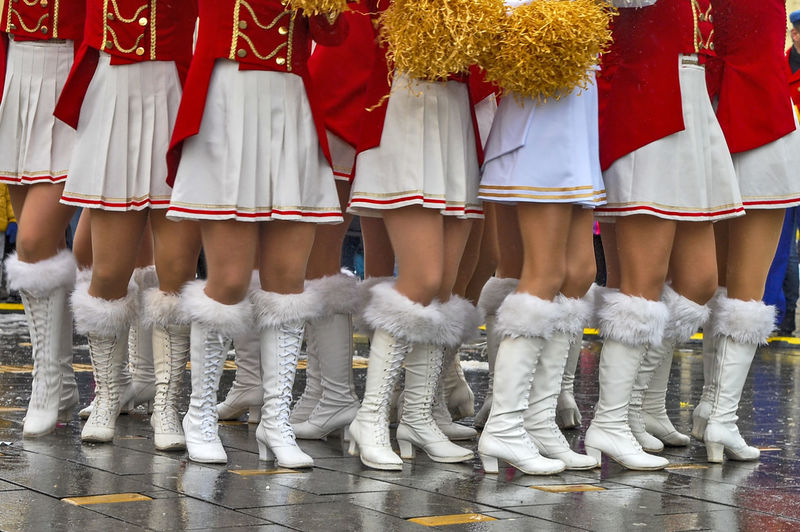 Low section of cheerleaders standing at footpath
