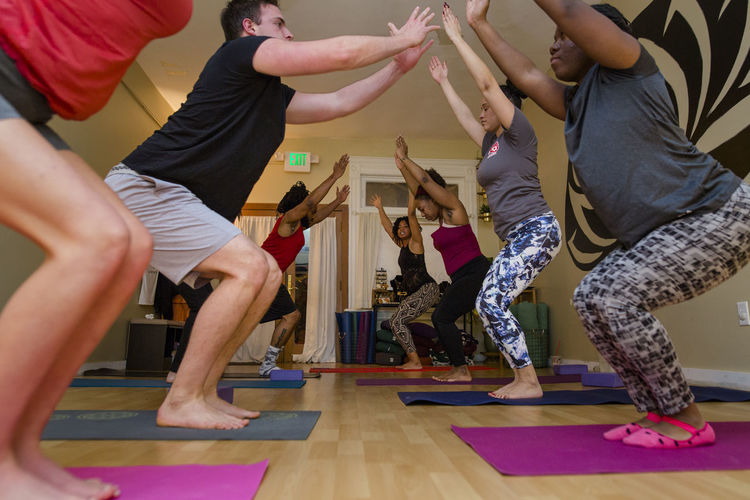 A small group of students practice yoga poses together