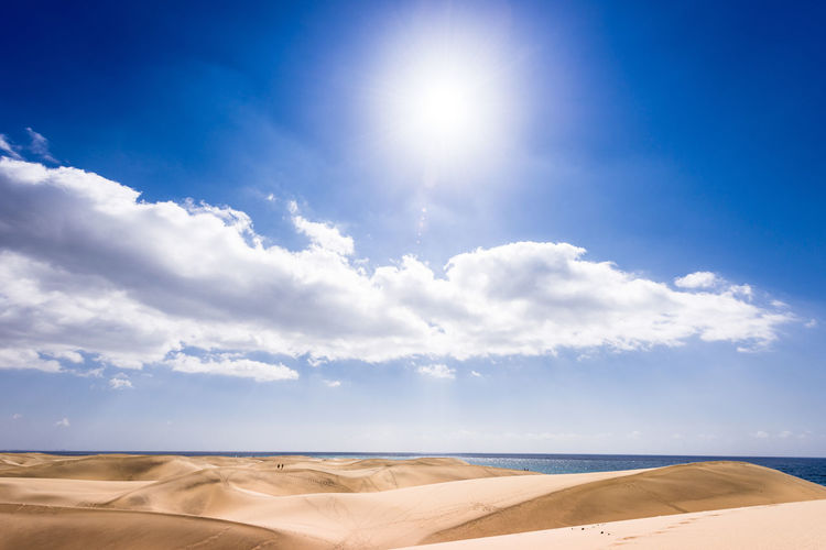 Scenic view of sand dunes against sky