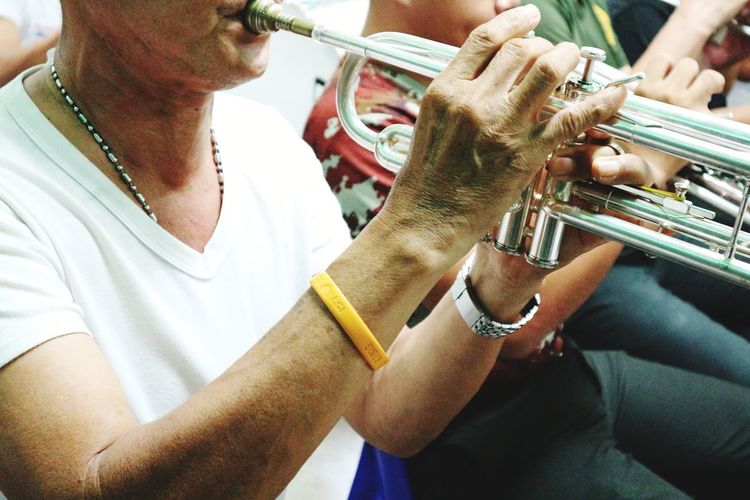 Midsection of man playing trumpet 