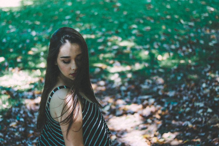 Side view of young woman standing at park