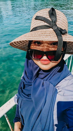 Portrait of girl wearing hat against sea
