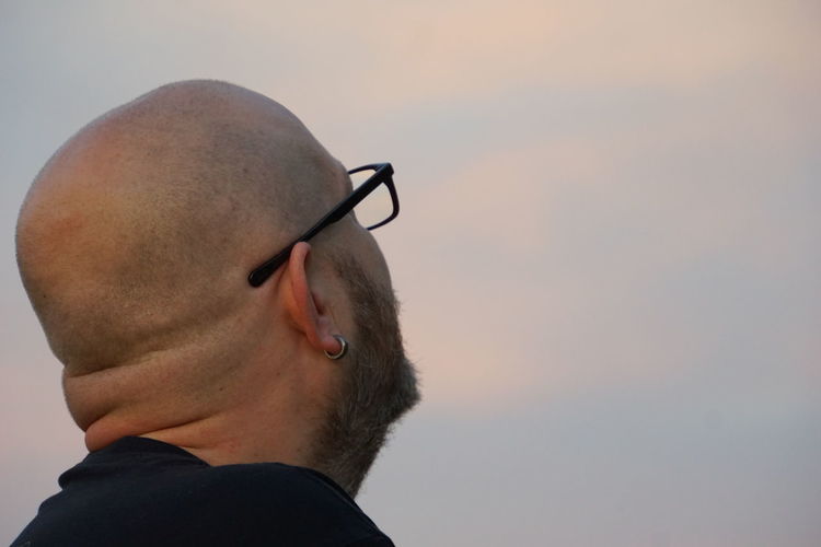 Close-up of bald man looking in sky
