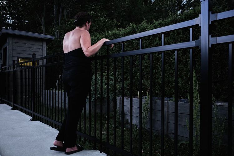 Rear view of man standing by railing