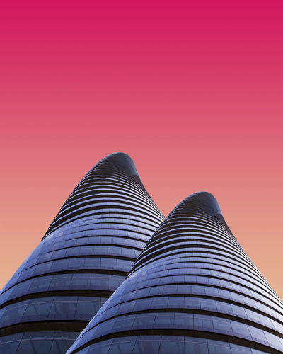 Low angle view of modern building against sky during sunset
