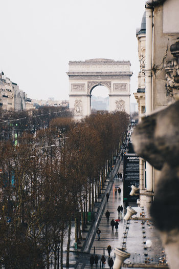 People walking in front of arc de triomphe against sky