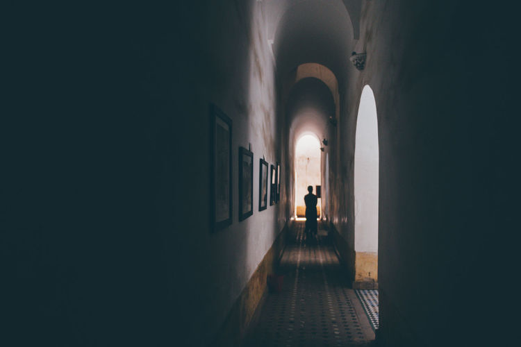 Silhouette man standing in corridor of building