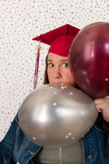 Portrait of young woman holding balloons