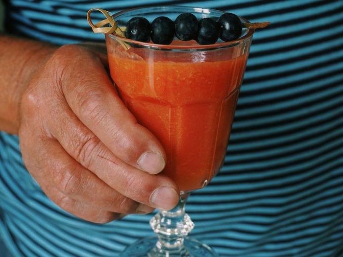 Close-up midsection of man holding juice