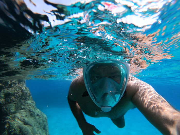 Mature man swimming under sea