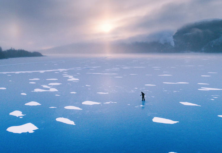 High angle view of man walking on frozen lake