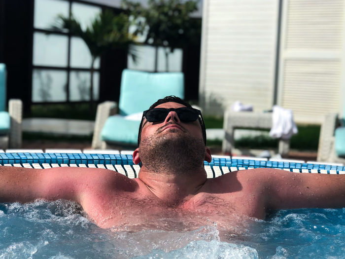 Shirtless man relaxing in swimming pool