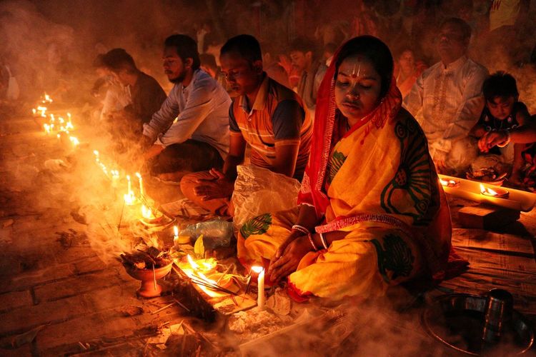 Doing prayer at barodi lokhnath brahmachari ashram infront of burning candle and diya- oil lamp