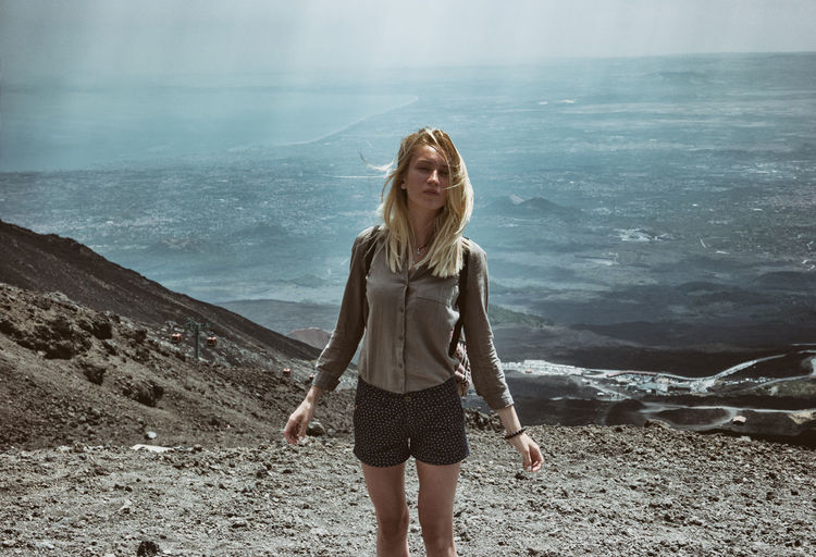 Portrait of young woman standing on mountain