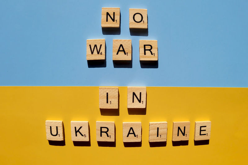 A lot of yellow stickers with words on blue background. concept of  support. stop war in ukraine