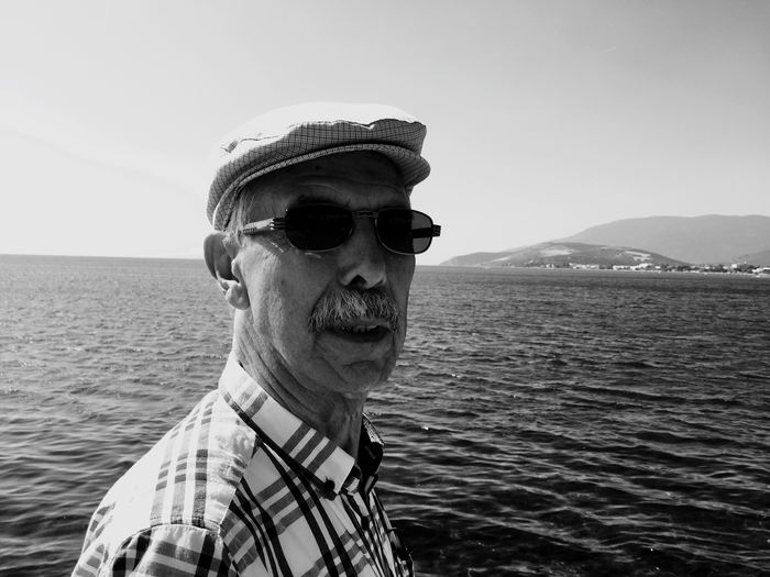 Portrait of man wearing sunglasses against sea and sky