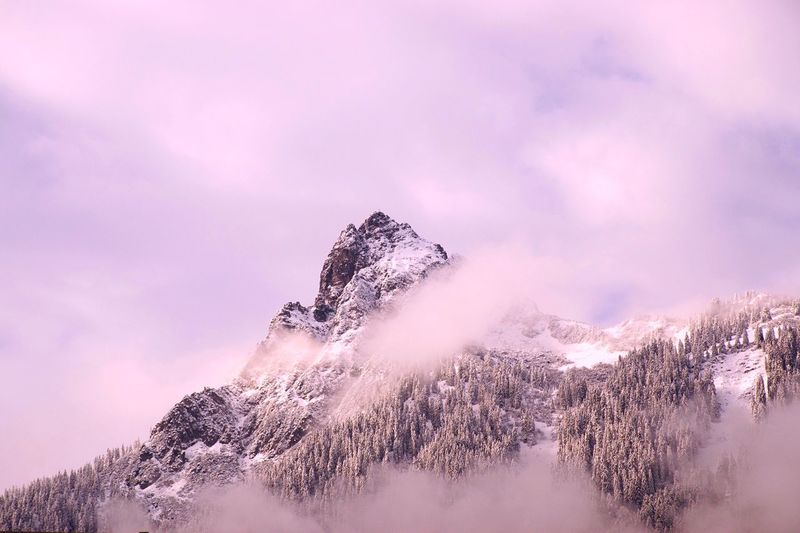 Low angle view of snowcapped mountain against cloudy sky