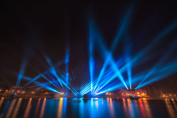 Illuminated bridge over river at night