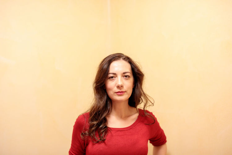 Portrait of woman against yellow wall