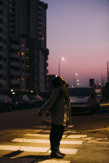 Rear view of woman walking on road at night