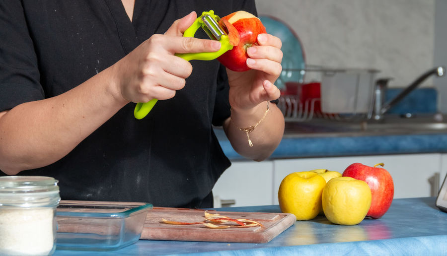 Midsection of woman holding fruits on table