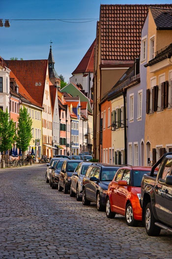 Cars on street by buildings against sky