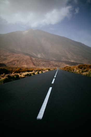 Empty road against mountain range