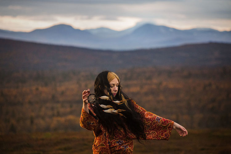 Woman with feather on a mountain 
free spirit 