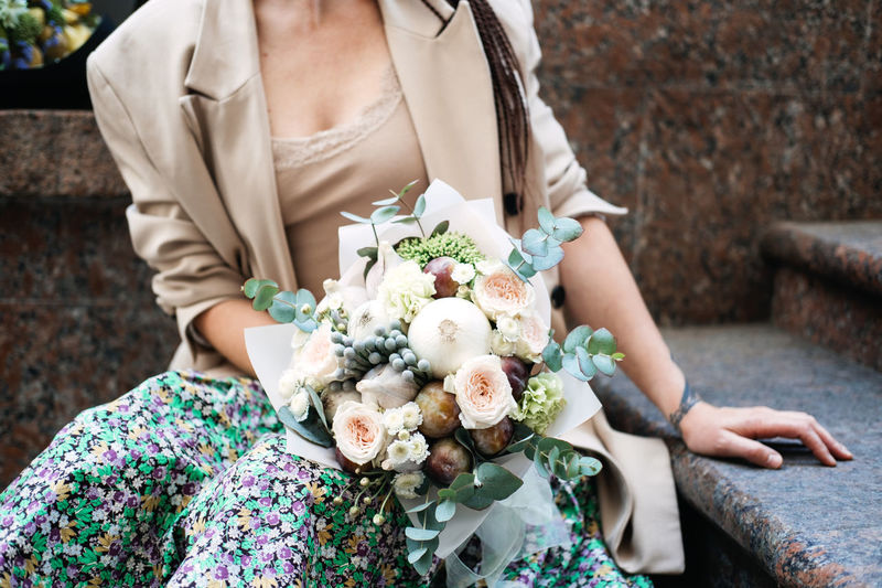 Flowers delivery. faceless portrait of woman with receiving beautiful flowers bouquet from delivery