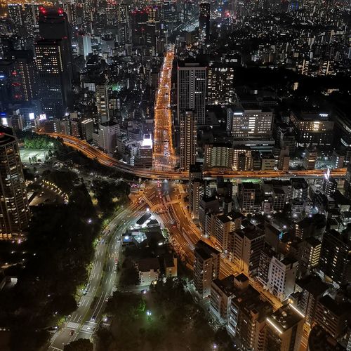 High angle view of illuminated highway amidst buildings in city at night