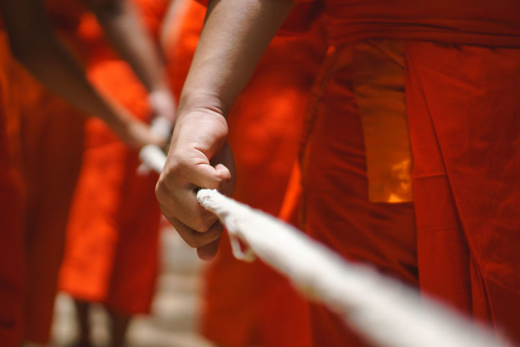 Midsection of monks wearing traditional clothing