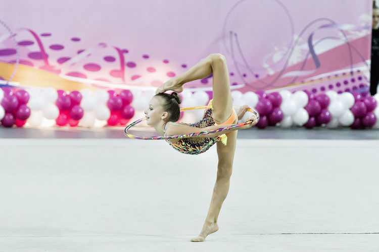 Full length side view of ballet dancer stretching on floor