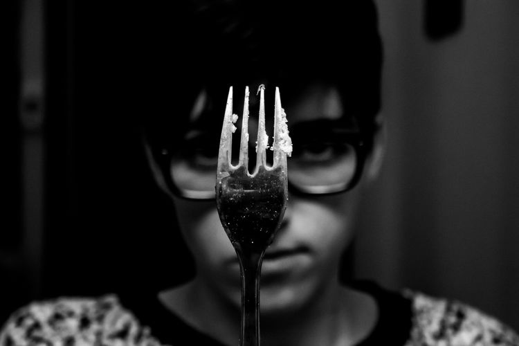 Close-up portrait of woman with fork in darkroom