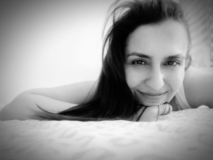 Portrait of young woman lying down on bed