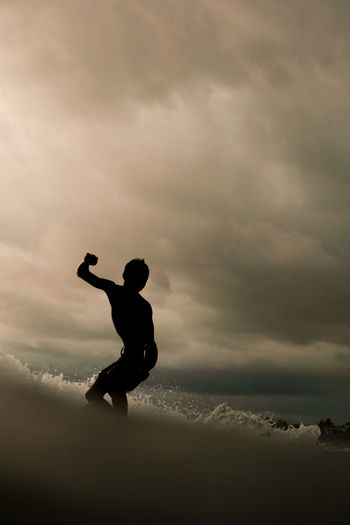 Silhouette of a man surfing against pink sky in bali