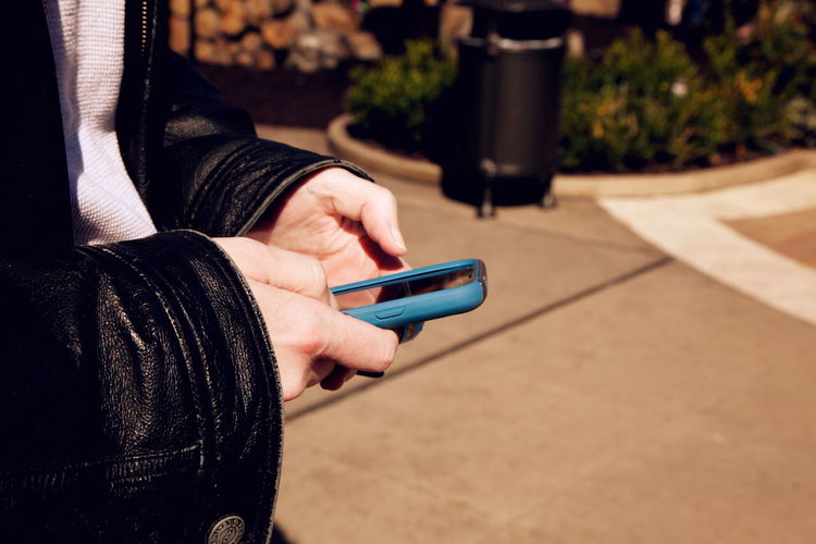 Cropped image of person using smart phone
