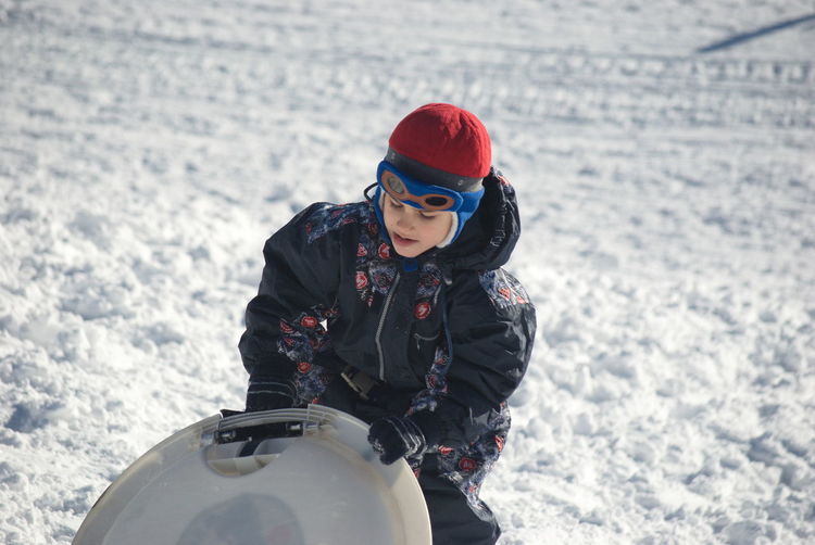 Boy with sled walking on snow