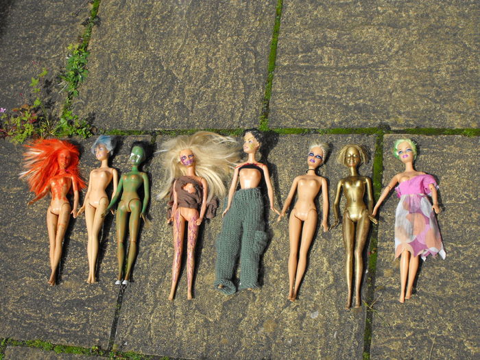 High angle view of abandoned dolls in row on footpath