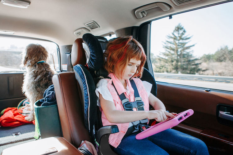 Girl using digital tablet in car